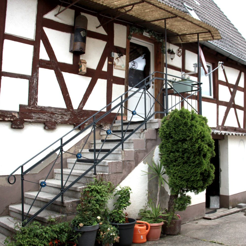 Eine Außentreppe mit Geländer führt zum Eingang des historischen Fachwerkhauses Ferienhaus QuarTIER in Böchingen.